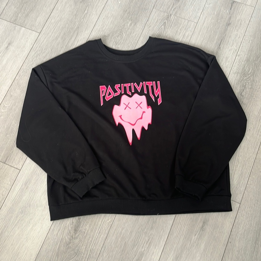 Black sweater with pink positivity smiley face
